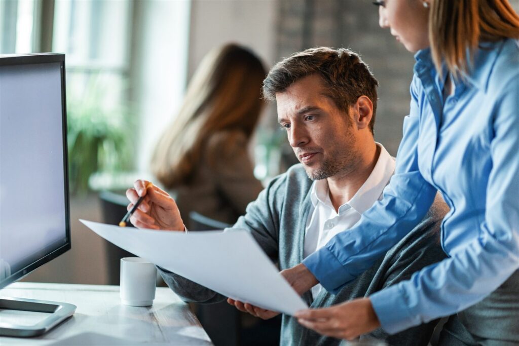 Two colleagues reviewing a document together at a desk
